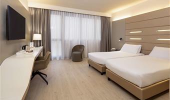 standard doppelzimmer, ca.<br /><br />25 m², 2 einzelbetten, kostenloses wlan, wasserkocher, minibar, 1 flaschen wasser, safe, lcd-tv mit sky-kanälen, kostenlose parkplätze und fitnessraum in der 18.<br /><br />etage