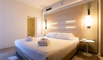 junior suite zimmer, ca.<br /><br />44 qm, 1 king size doppelbett und 1 einzelschlafcouch, schreibtisch, kostenloses wlan, wasserkocher, bademantel mit pantoffeln und toilettenartikeln, minibar, segafredo-maschine, safe, lcd-tv mit sky-kanälen und chromecast, kostenloser parkplatz und fitnessraum im 18.<br /><br />stock, besonderer empfang (1 glas wein mit snacks)