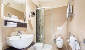 superior zimmer mit balchony mit kingsize-bett cabrio in 2 einzelbetten und einem einzelbett, sofa und einer kostenlosen flasche wasser