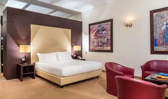 superior room with balchony with king size bed convertible in 2 twin beds and a single bed, sofa and free bottle of water